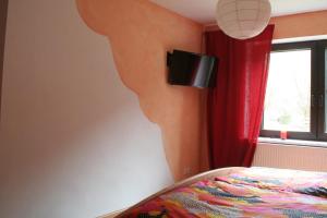 1 dormitorio con 1 cama y TV en la pared en Ferienhaus Geipel, en Wohlbach