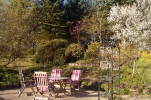 three chairs and a table in a garden at Ferienhaus Geipel in Wohlbach