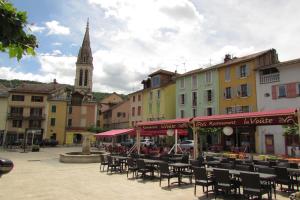 a town square with tables and chairs and a church at T2 à Gap in Gap