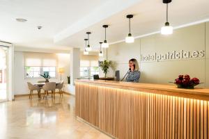 a woman talking on a phone behind a counter in a restaurant at Hotel Patricia Menorca in Ciutadella +36 photos