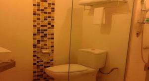 Un baño con inodoro y ducha de cristal. en Hotel Puri 36, en Inanam 67 fotos más