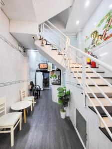 a staircase in a room with tables and chairs at H2T Hotel Center BuiVien in Ho Chi Minh City