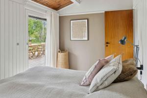 ein Schlafzimmer mit einem Bett mit Kissen und einem Fenster in der Unterkunft Cozy Holiday Home Near Rødby in Rødby