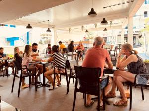 a group of people sitting at tables in a restaurant at Villa White in Ksamil