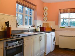 a kitchen with a sink and a dishwasher at Low Mill Cottage in Grassington