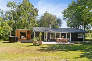 ein kleines Haus mit einer Terrasse und einem Tisch in der Unterkunft Cozy Holiday Home Near Rødby in Rødby