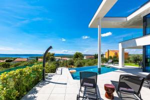 プナトにあるLuxury Villa 45の椅子とプールのあるパティオ