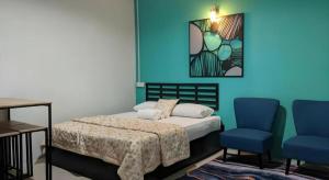a bedroom with a bed and two blue chairs at Hotel Mansya in Kota Bharu +93 photos