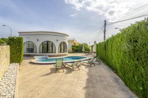 una piscina con sillas y una casa en Una villa de lujo con propio jardín y piscina, en Los Montesinos