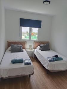 two beds sitting next to each other in a room at Confortable y luminoso bungalow en Maspalomas in Maspalomas +13 photos