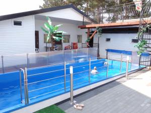 a swimming pool in front of a house at MAX Apartamenty - Pokoje - Domki - Restauracja - Basen in Mielno