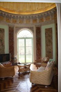 a living room with chairs and a large window at Chateau Castelrives in Bessières