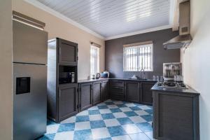a kitchen with brown cabinets and a checkered floor at lucky villas in Trou aux Biches