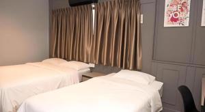 Giường trong phòng chung tại Ipoh Sakura Hotel