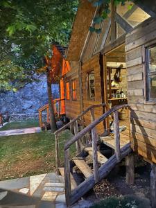 a painting of a log cabin with a porch at Bujtina Liqeni i Shkopetit in Madhesh