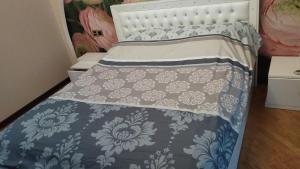 a bed with a blue and white comforter at Хорошем месте находится, улица Иззет Небиев 6-22 in Baku