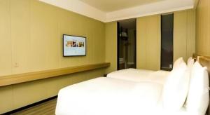 Postel nebo postele na pokoji v ubytování Borrman Hotel Xiamen Xiang'an Maxiang