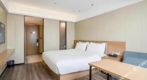 Postel nebo postele na pokoji v ubytování Borrman Hotel Xiamen Xiang'an Maxiang