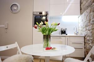 a vase of flowers on a table in a kitchen at Apartment White Stone - Diocletian Palace in Split