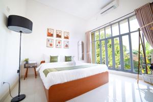 a bedroom with a bed and a large window at Family Villa in Central Sleman with Playground in Beran-kidul
