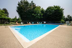 a swimming pool with blue water in a yard at Camping les Avenières in Manthes +41 photos