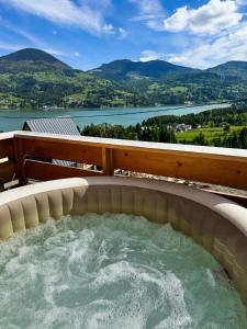 a hot tub with a view of a river and mountains at A Frame Girasole in Colibiţa