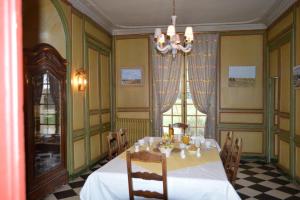 a dining room with a table and a chandelier at Ferme de la Vallière in Tancrou