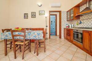 a kitchen with a table and chairs in a kitchen at Orsa Maggiore Ottiolu in Porto Ottiolu