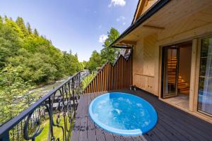 a hot tub on the deck of a house at Domek Sauna & Jacuzzi in Poronin