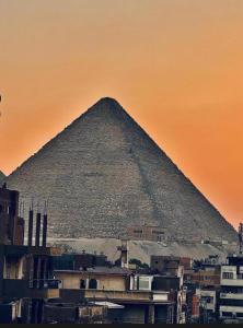 a pyramid in the background of a city at khufus pyramids hotel in Cairo