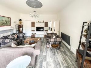 a living room with two couches and a table at Osborne Place in Rothesay