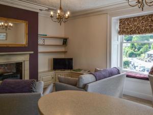 a living room with a table and a fireplace at 4 Harney Peak in Portinscale