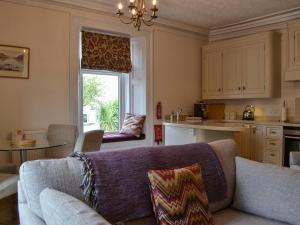 a living room with a couch and a kitchen at 4 Harney Peak in Portinscale +20 photos