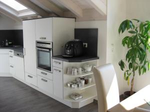 a kitchen with white cabinets and a plant at Bergblick Lodge in Ofterschwang