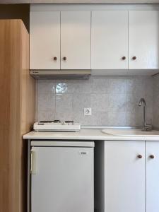 a kitchen with white cabinets and a sink and a dishwasher at ATHINA MARE-SOLE in Kallithea Halkidikis +21 photos