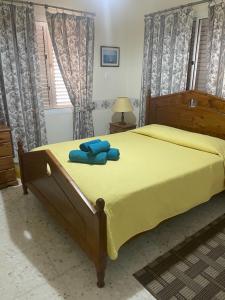 a bedroom with a yellow bed with blue towels on it at Villa Filip Coral Bay in Peyia +68 photos