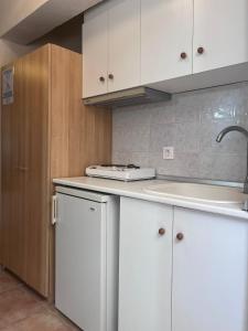 a kitchen with white cabinets and a sink at ATHINA MARE-SOLE in Kallithea Halkidikis