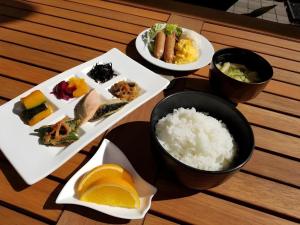 a table with plates of food and bowls of rice at Pearl Hotel Mizonokuchi in Takatsu-ku