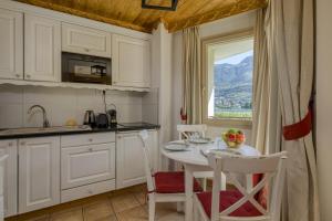 デュアンにあるRoseaux du Lacのテーブルと椅子と窓のあるキッチン