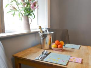 a table with a bucket and a bowl of oranges on it at Bluebell Cottage in Alnwick