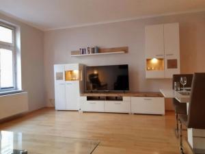 ein Wohnzimmer mit einem großen TV und weißen Schränken in der Unterkunft Kutter - ABC200 in Wismar