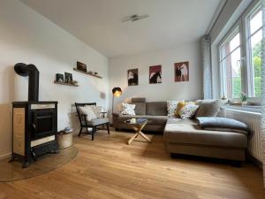 a living room with a couch and a fireplace at Ferienhaus "De lütten Tieden" 65358 in Moormerland