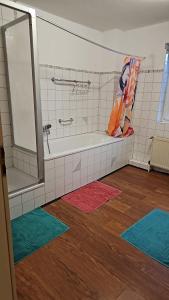 a bathroom with a tub and colorful rugs on the floor at Gesamt Unterkunft Rheinhaus in Bonn