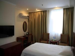 una camera d'albergo con un letto e una grande finestra di GreenTree Inn Changshu South HaiYu Road Pedestrian Street Business Hotel a Suzhou Altre 268 foto