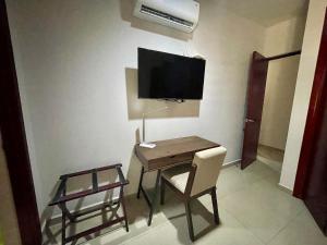 a room with a desk and a tv on the wall at Charming Condo in Gaviotas Walk to Beach cafes, restaurants within Golden Zone in Mazatlán