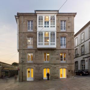 a man standing in front of a brick building at Hotel Pazo de Altamira in Santiago de Compostela