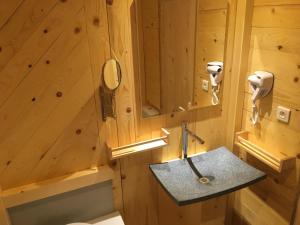 a wooden bathroom with a sink and a mirror at Relais Mont Jura Adults Only in Lélex +59 photos
