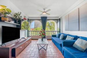 Una sala de estar con un sofá azul y un televisor en Duplex Chill Beach, en Denia