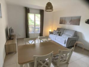 un salon avec une table et un canapé dans l'établissement Les Jasmins, à La Croix-Valmer