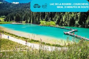a view of a lake with a pier and people on the beach at Studio Alpin & Bien-Être in Brides-les-Bains